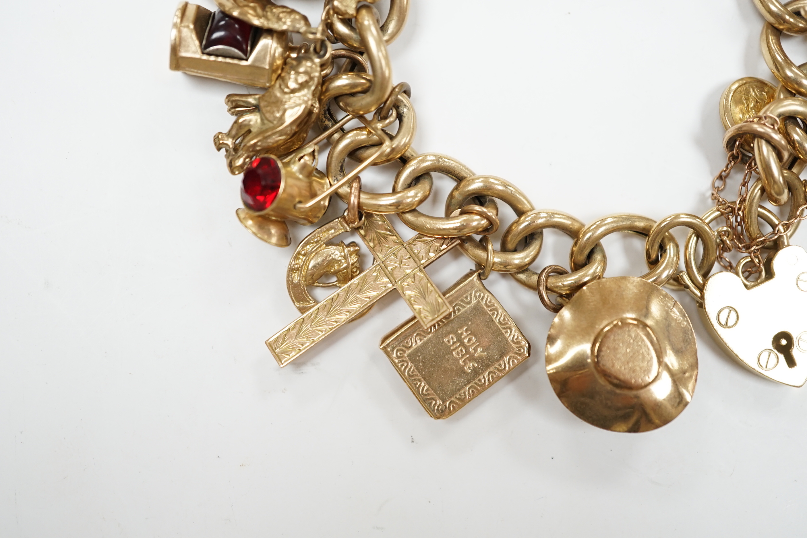 An early 1960's 9ct gold curb link charm bracelet, hung with fifteen assorted charms, including twelve 9ct gold, gross weight 49.7 grams.